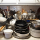 Image description: A neatly arranged set of kitchen cabinets with labeled shelves for specific items such as plates, cups, spices, and pots and pans.