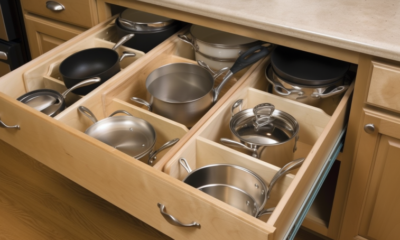 An image of neatly organized kitchen cabinets with dishes, cups, and utensils in designated spaces. The alt text could read: "A well-organized kitchen cabinet with plates, cups, and utensils arranged in their designated spaces. Tips for organizing kitchen cabinets include sorting items by frequency of use, using drawer dividers, and labeling containers."